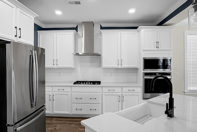 661 Black Pine Rd, Moncks Corner, SC 29461 - kitchen with stainless steel appliances, wall chimney exhaust hood, ornamental molding, light countertops, and white cabinetry