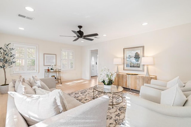 living room with ceiling fan and light hardwood / wood-style flooring