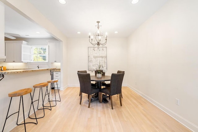 dining room featuring light wood-type flooring and a chandelier