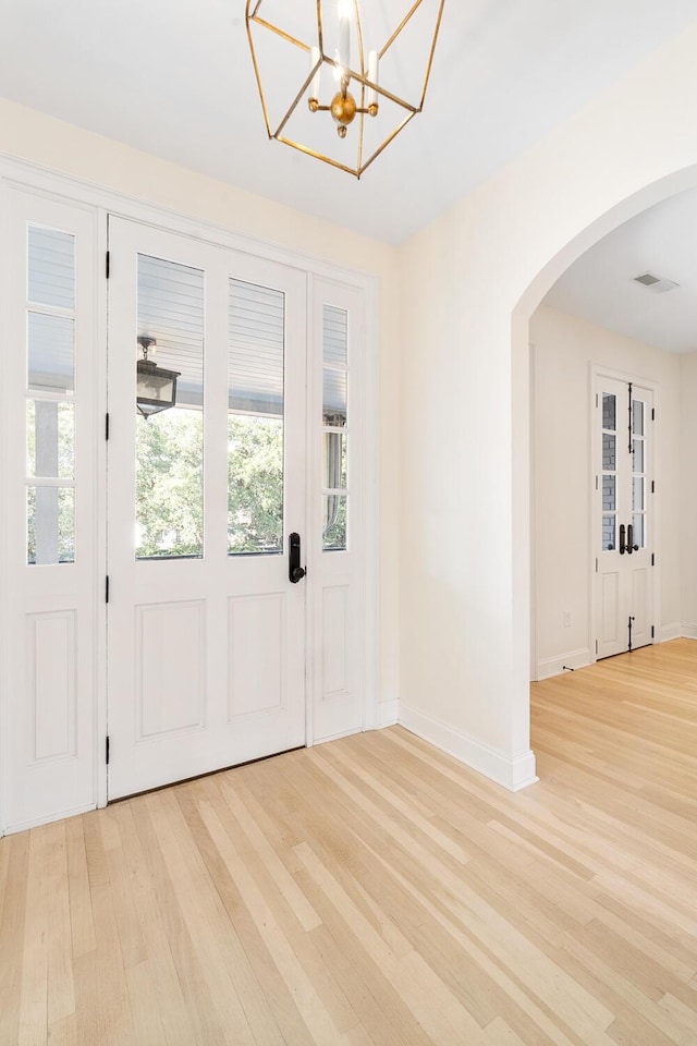 entrance foyer with a chandelier and light hardwood / wood-style flooring