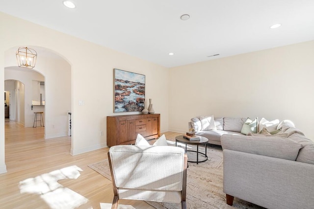 living room with a notable chandelier and light wood-type flooring