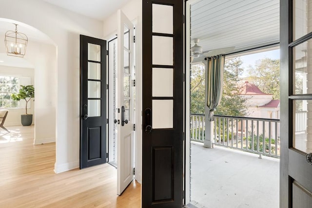 entryway with light hardwood / wood-style floors, a wealth of natural light, and a chandelier