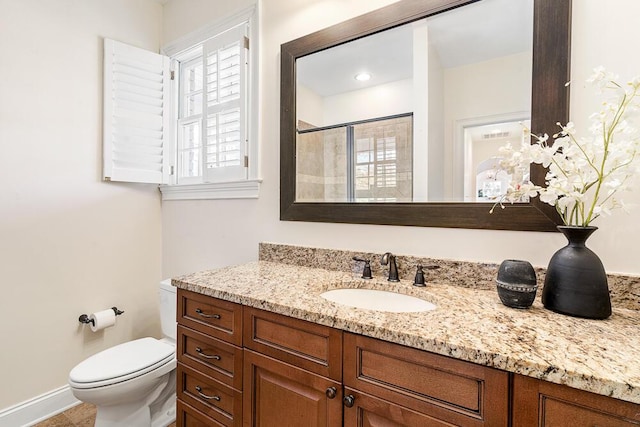 bathroom with toilet, a shower with door, and vanity