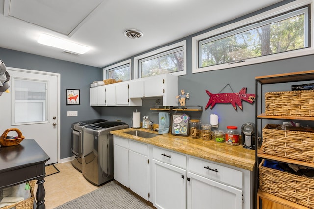 2500 The Bent Twig, Seabrook Island, SC 29455 - washroom featuring cabinet space, washer and clothes dryer, light tile patterned floors, and baseboards