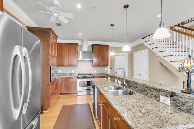 225 Seven Farms Dr Unit 307, Daniel Island, SC 29492 - kitchen featuring appliances with stainless steel finishes, wall chimney range hood, brown cabinets, a ceiling fan, and light wood finished floors