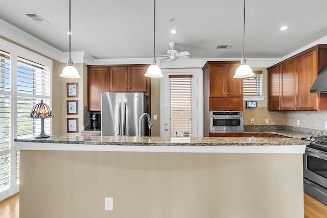 225 Seven Farms Dr Unit 307, Daniel Island, SC 29492 - kitchen featuring appliances with stainless steel finishes, decorative backsplash, light stone counters, a ceiling fan, and pendant lighting