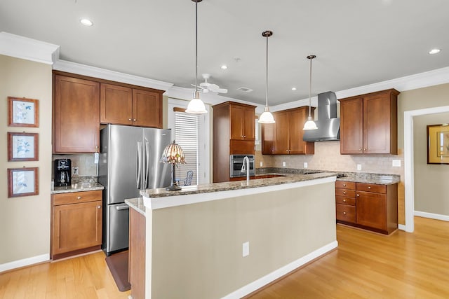 225 Seven Farms Dr Unit 307, Daniel Island, SC 29492 - kitchen with wall chimney range hood, freestanding refrigerator, light wood-style flooring, backsplash, and a kitchen island with sink