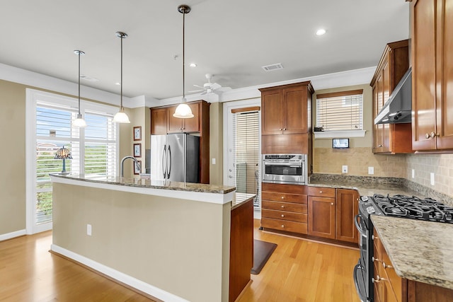 225 Seven Farms Dr Unit 307, Daniel Island, SC 29492 - kitchen with stainless steel appliances, an island with sink, light wood-style floors, decorative backsplash, and recessed lighting