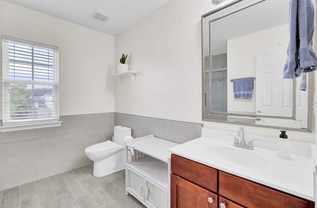 145 Woodbrook Way, Moncks Corner, SC 29461 - bathroom featuring toilet, vanity, tile walls, and a wainscoted wall