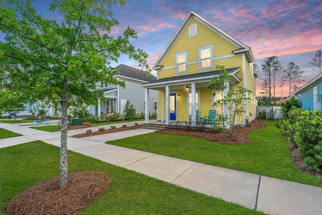 view of front of house featuring covered porch and a yard