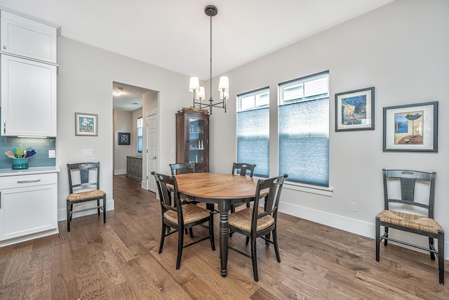 dining room featuring baseboards, a chandelier, and wood finished floors