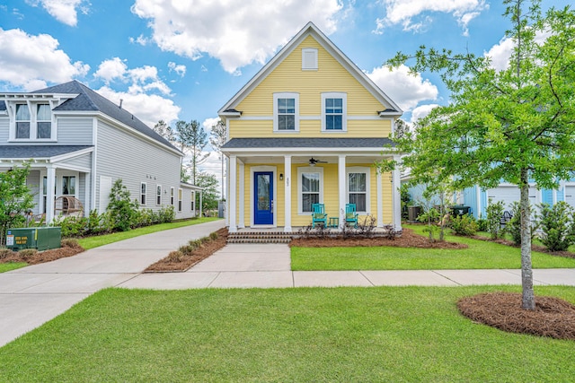 view of front of house with covered porch, ceiling fan, and a front lawn