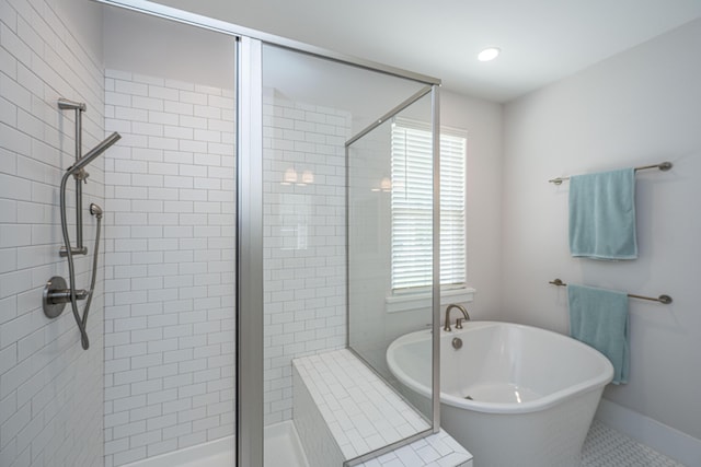 bathroom featuring a shower stall, a soaking tub, and a wealth of natural light