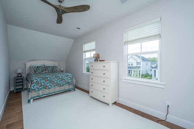 bedroom with visible vents, baseboards, ceiling fan, and wood finished floors