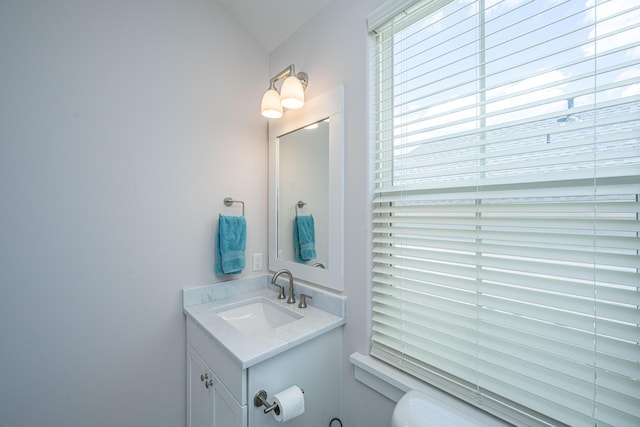 bathroom with vanity, vaulted ceiling, and toilet