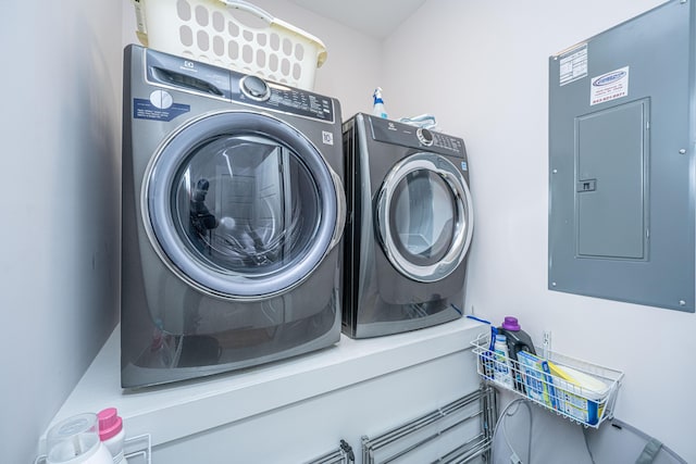 laundry room with electric panel, washer and clothes dryer, and laundry area