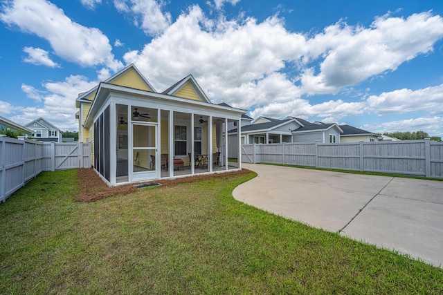 rear view of house featuring ceiling fan, a patio, a fenced backyard, a sunroom, and a yard