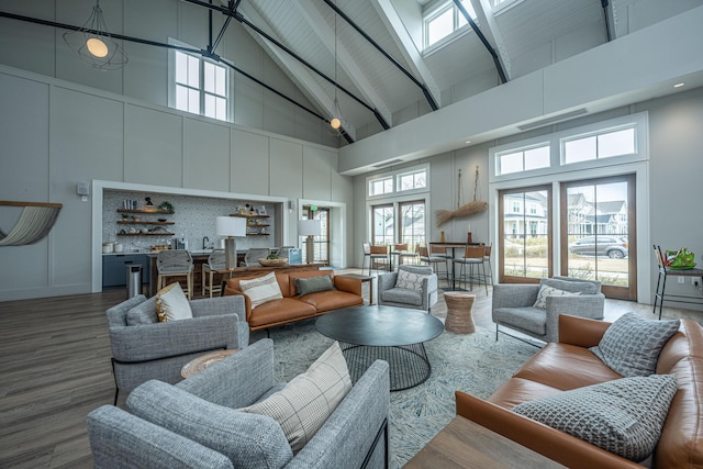 living room with wood finished floors, beam ceiling, and high vaulted ceiling