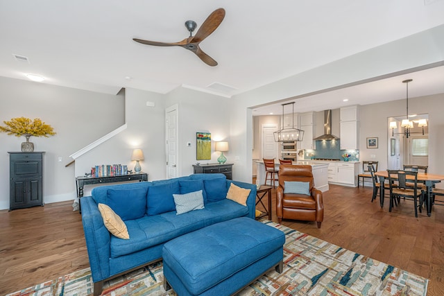 living area with visible vents, recessed lighting, ceiling fan with notable chandelier, and wood finished floors