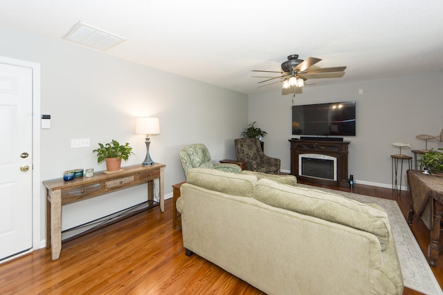 living room with a fireplace, hardwood / wood-style floors, and ceiling fan