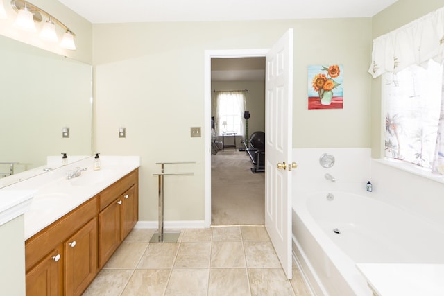 bathroom featuring a bathing tub, vanity, and tile patterned flooring