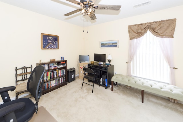 carpeted home office with ceiling fan and a healthy amount of sunlight