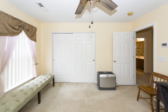 living area featuring ceiling fan and light carpet