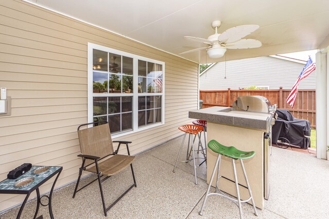 view of patio featuring exterior bar, grilling area, and ceiling fan