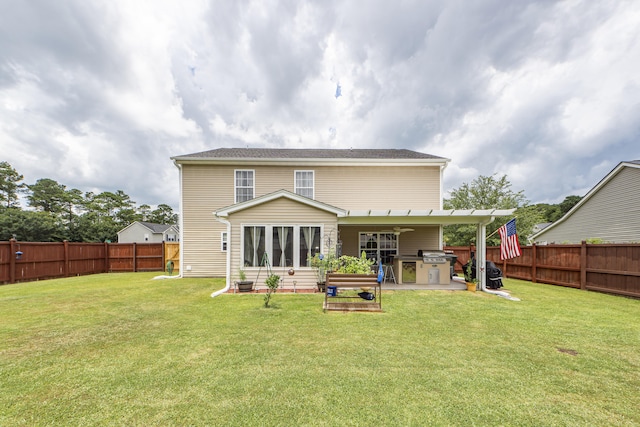 rear view of property with a lawn and an outdoor kitchen