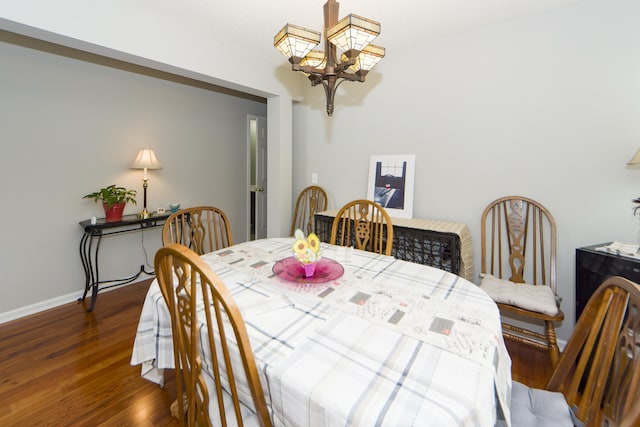 dining area featuring dark hardwood / wood-style floors and an inviting chandelier