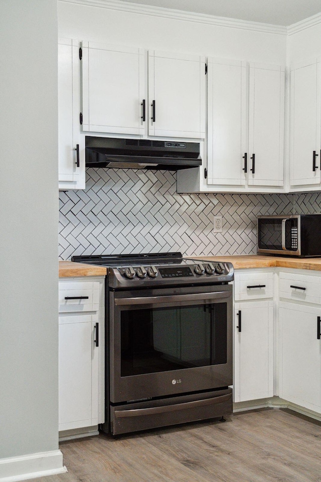 kitchen with wood counters, light wood finished floors, under cabinet range hood, and stainless steel appliances