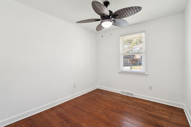 empty room featuring dark wood-type flooring, baseboards, visible vents, and ceiling fan