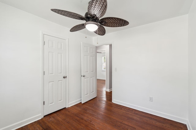 unfurnished bedroom with dark wood finished floors, ceiling fan, and baseboards