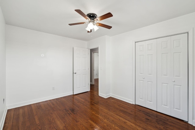 unfurnished bedroom with a closet, baseboards, ceiling fan, and dark wood-style flooring