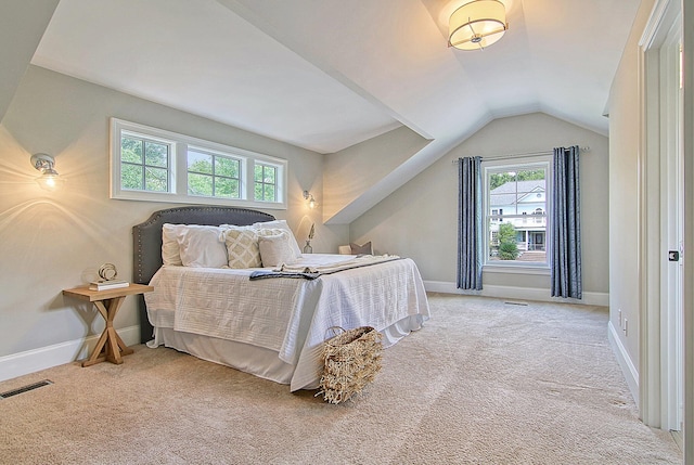 carpeted bedroom featuring multiple windows and lofted ceiling