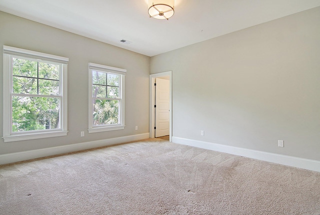 empty room with a wealth of natural light and light colored carpet