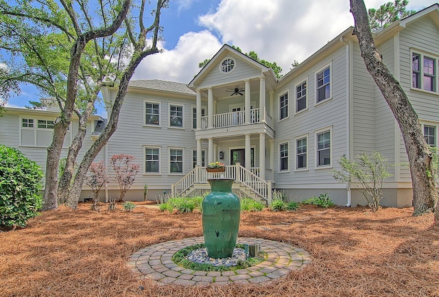 back of house with ceiling fan and a balcony