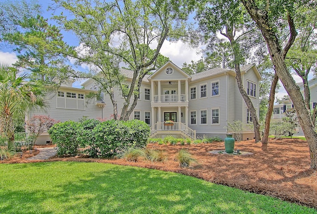 view of front of house featuring a front lawn and a balcony