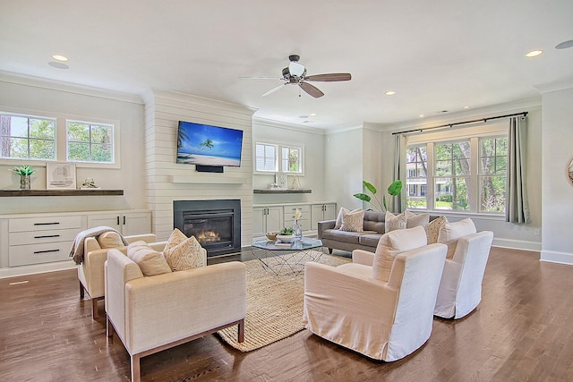 living room featuring crown molding, ceiling fan, dark hardwood / wood-style flooring, and a fireplace