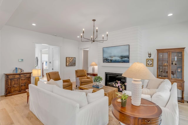 living room with a notable chandelier and light wood-type flooring