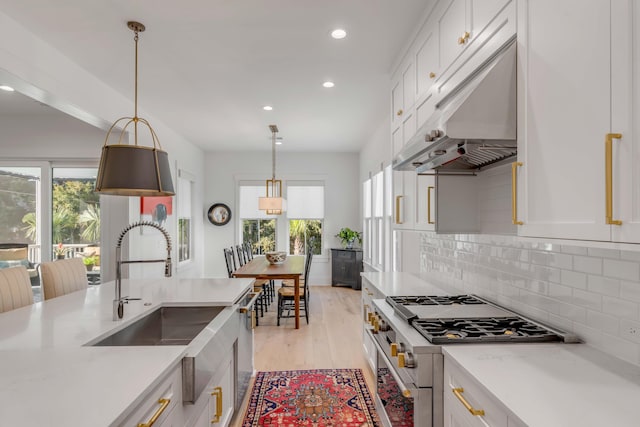 kitchen with appliances with stainless steel finishes, white cabinetry, and light wood-type flooring