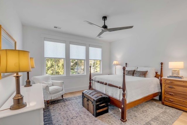 bedroom with multiple windows, light hardwood / wood-style floors, and ceiling fan