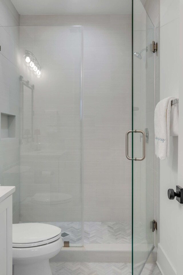 bathroom with vanity, walk in shower, and toilet