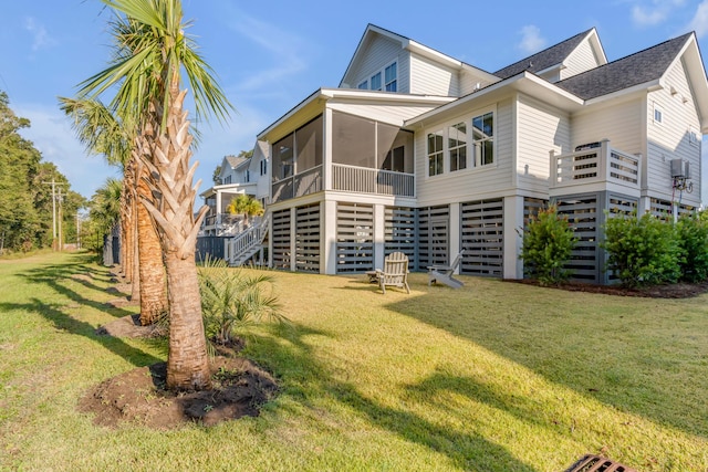 rear view of property with a lawn and a sunroom