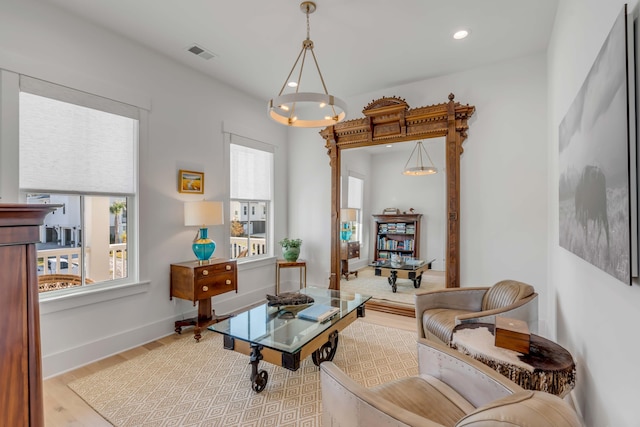 living area with light hardwood / wood-style flooring and an inviting chandelier