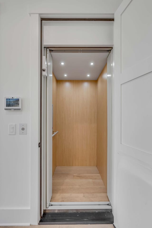 room details with hardwood / wood-style floors and elevator