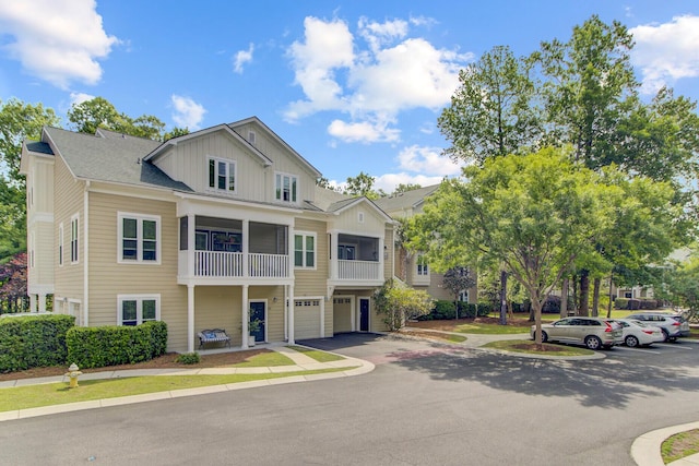 view of front of home with board and batten siding, a garage, driveway, and a balcony