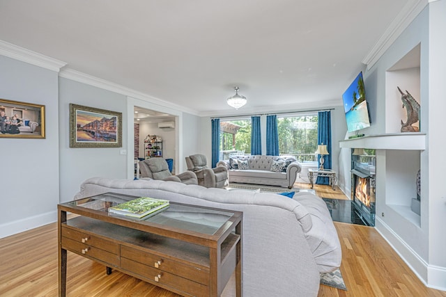 living area featuring wood finished floors, baseboards, a wall unit AC, crown molding, and a premium fireplace