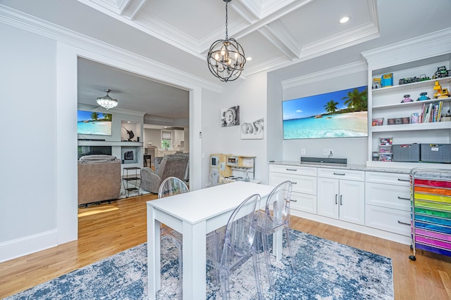 dining room featuring ornamental molding, a chandelier, light wood finished floors, beam ceiling, and coffered ceiling