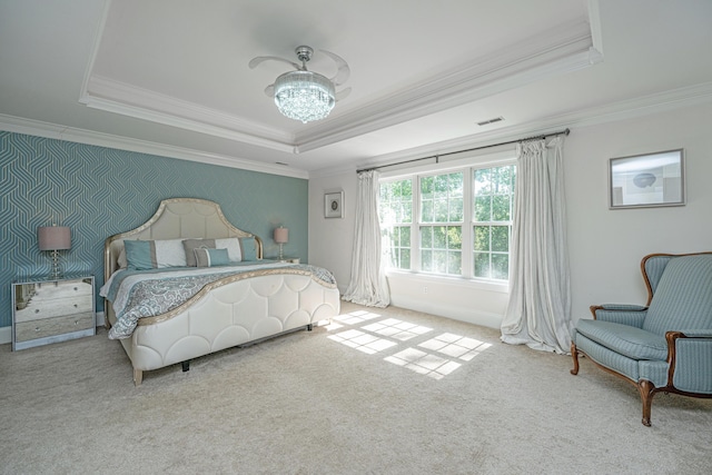 bedroom with ornamental molding, a tray ceiling, carpet floors, and a chandelier